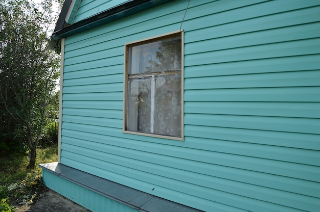 Schönes landhaus, bedeckt mit grünen abstellgleisen, sommertag.