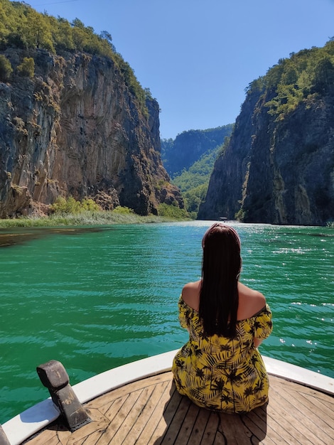 Foto schönes mädchen auf dem deck eines bootes während einer fahrt auf dem meer mit blick auf die berge