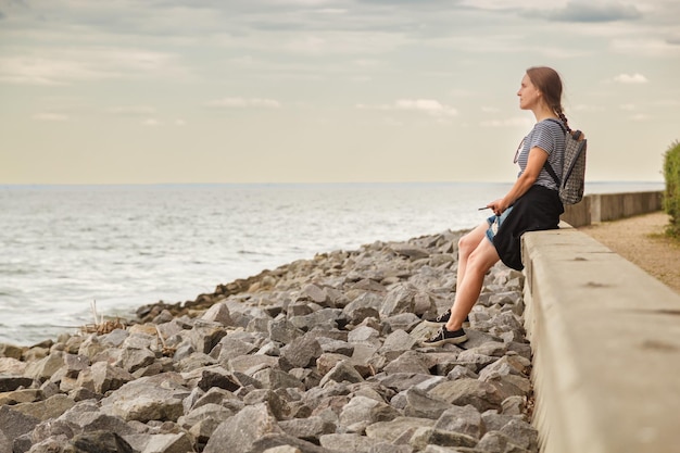 Schönes Mädchen auf dem Meer mit blauem Himmel und Wolken