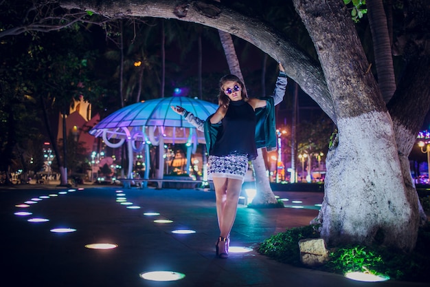 Schönes Mädchen auf einem Hintergrund der Nachtbeleuchtung in Asien