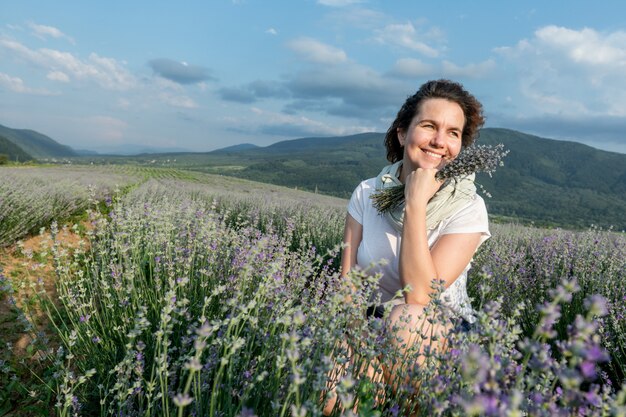 Schönes Mädchen auf einem Lavendelfeld genießt die Landschaft und den Geruch