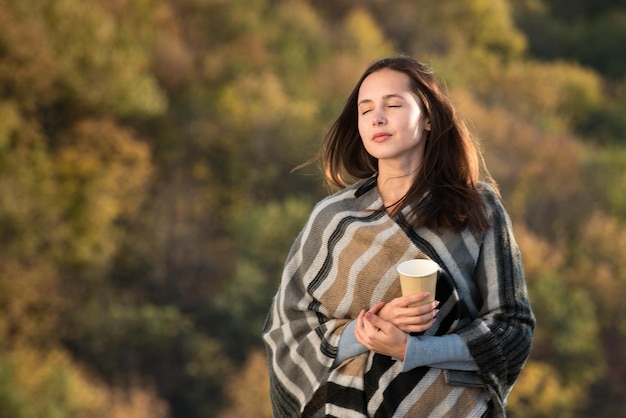 Schönes Mädchen auf Naturhintergrund der Träume Reisen Sie im Herbst Kaffee in der Hand