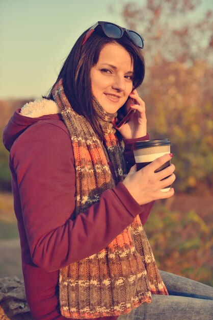 Schönes Mädchen, das Kaffee im Park genießt