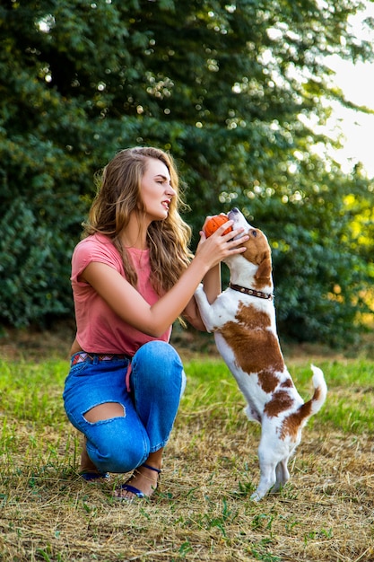 Schönes Mädchen, das mit einem Beagle-Welpen spielt