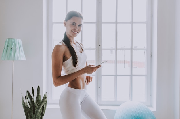 Schönes Mädchen, das Training und Yoga zu Hause am Morgen macht