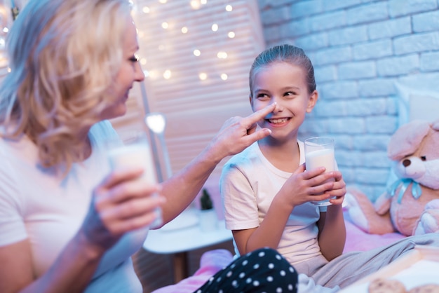 Schönes Mädchen genießen Milch und Kekse