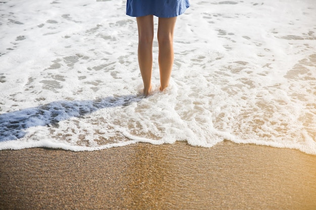 Schönes Mädchen im blauen Kleid geht am Strand Erstaunliches Sommerfoto Frau in der Nähe des Meeres Urlaubsreisekonzept Schlanke Beine Warmes Meerwasser