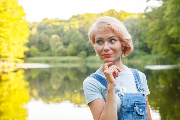 Schönes Mädchen im Hintergrund am Ufer vor dem Hintergrund des Sees