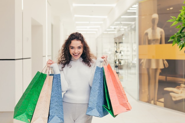 Schönes Mädchen im Laden mit farbigen Taschen