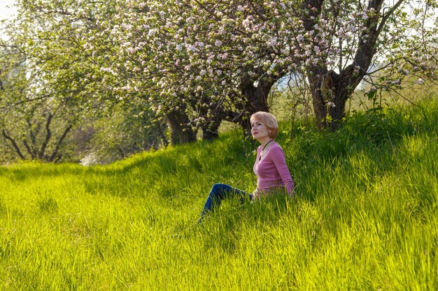 Schönes Mädchen in den Armen eines Kindermädchens in einem blühenden Park