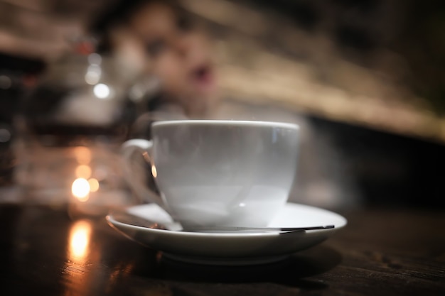 Schönes Mädchen in einem Café, das bei einem Abendessen eine Tasse Kaffee trinkt