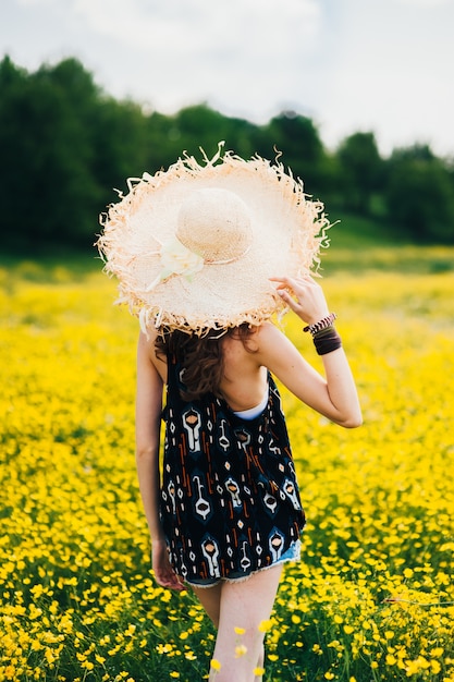 schönes Mädchen in einem Feld von gelben Blumen