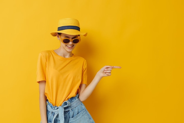 Schönes Mädchen in einem gelben Hut Freizeitkleidung im Jugendstil mit Sonnenbrille Lifestyle unverändert