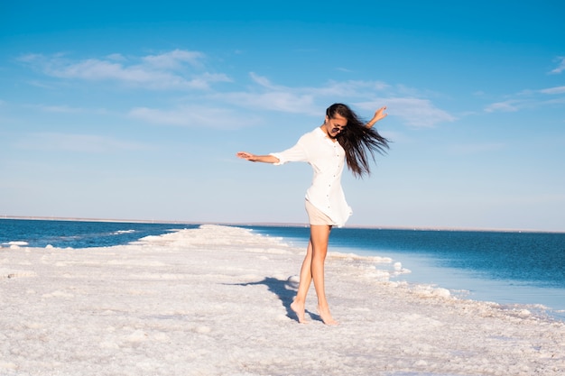 Schönes Mädchen in einem Strandkleid am Meer. Frau auf einem Salzsee. Ruhe am Toten Meer.