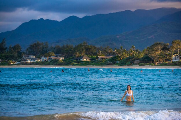 Schönes Mädchen in einem weißen Bikini schwimmt im Meer an einem paradiesischen Strand auf Oahu auf der Insel Hawaii