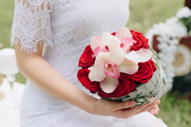 schönes Mädchen in einem weißen Kleid mit einem Blumenstrauß