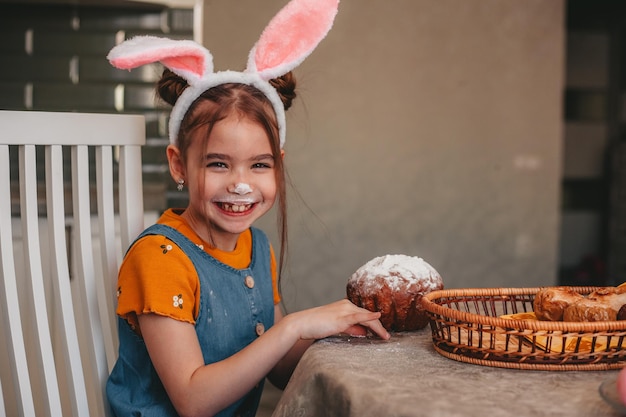 Schönes Mädchen in Hasenohren malen Ostereier