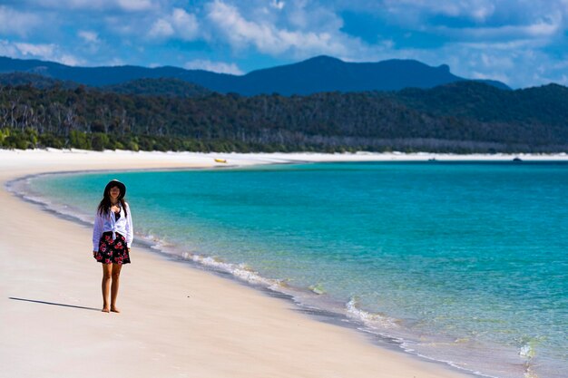 schönes mädchen in kleid und hemd und hut geht am whitehaven beach, whitsunday island, australien