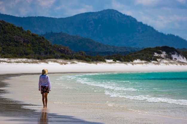 schönes mädchen in kleid und hemd und hut geht am whitehaven beach, whitsunday island, australien