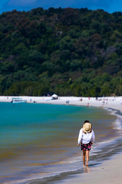 schönes mädchen in kleid und hemd und hut geht am whitehaven beach, whitsunday island, australien
