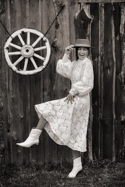 Foto schönes mädchen in vintage-spitzenkleid und hut auf der ranch