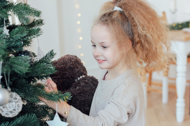 Schönes Mädchen mit 8-Jährigen nahe bei Weihnachtsbaum