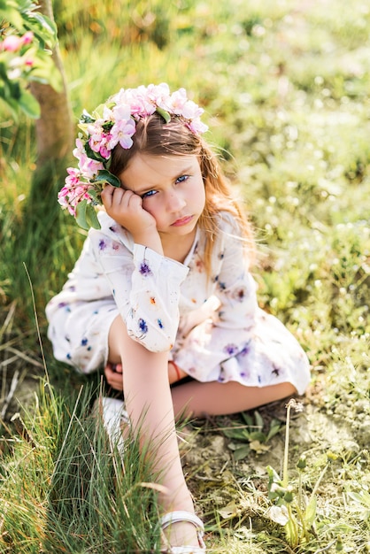 Schönes Mädchen mit Blumenkranz in der Natur