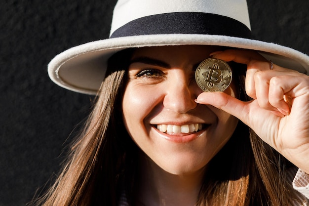 Schönes Mädchen mit Brille aus Bitcoin Bitcoin-Kryptowährung Sexy Frau mit Bitcoin isoliert auf Bullenmarkt im Freien