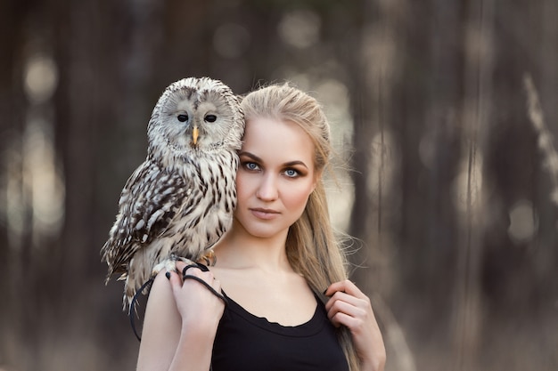 Schönes Mädchen mit der langen Haarnatur, Eule halten