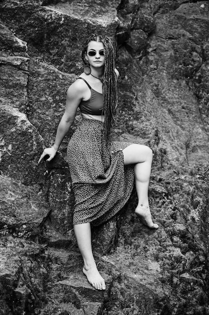 Schönes Mädchen mit Dreadlocks im Hippie-Stil posiert im Freien