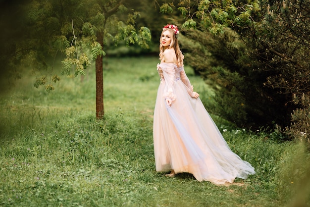 Schönes Mädchen mit einem eleganten Kleid in einem Garten