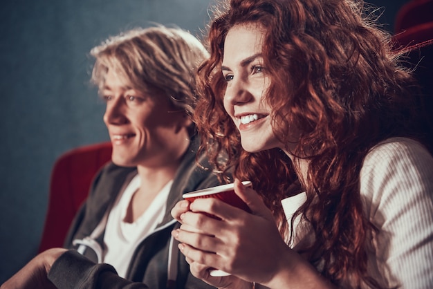 Schönes Mädchen mit Freund, der Kino sieht.