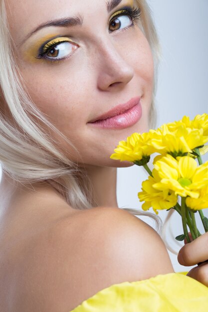 Schönes Mädchen mit gelben Blumen