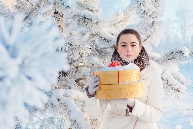 Schönes Mädchen mit Geschenk im Winterpark