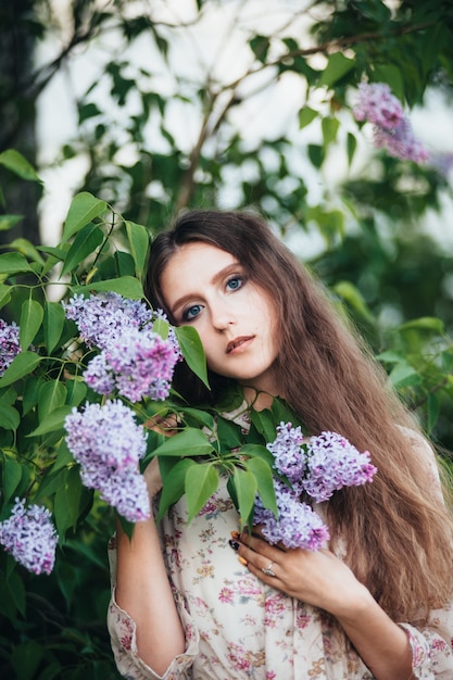 Schönes Mädchen mit großen Augen nahe dem lila Baum.