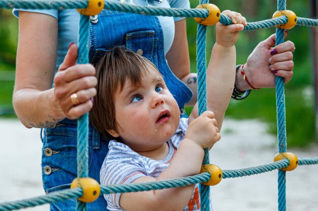 Schönes Mädchen mit Kindern auf einem Kinderspielplatz