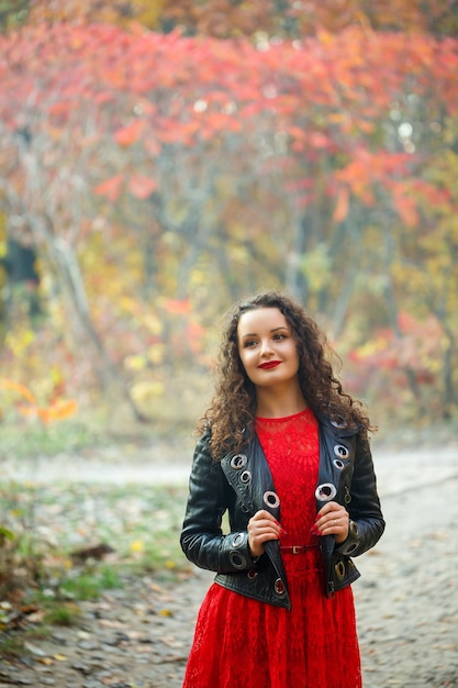 Schönes Mädchen mit Locken im Herbstpark