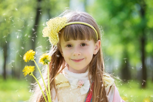 Schönes Mädchen mit Löwenzahn Porträt eines fünfjährigen Babys mit Blumen