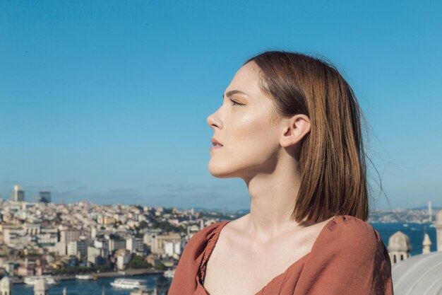 Schönes Mädchen mit orangefarbenem Kleid, das mit der Istanbul-Szene posiert