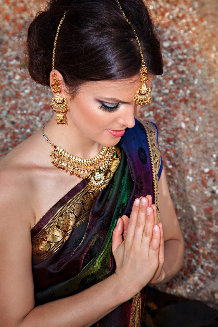 Schönes Mädchen mit orientalischem Make-up, indischem Sari und indischem Schmuck