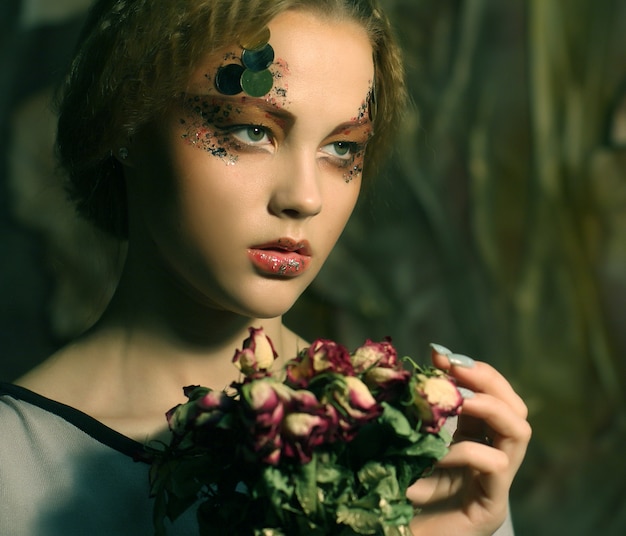 Schönes Mädchen mit trockenen Rosen