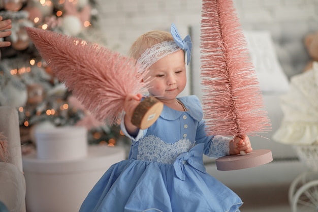 Schönes Mädchen mit Weihnachtsbaum Happy Baby feiert Weihnachten und Neujahr