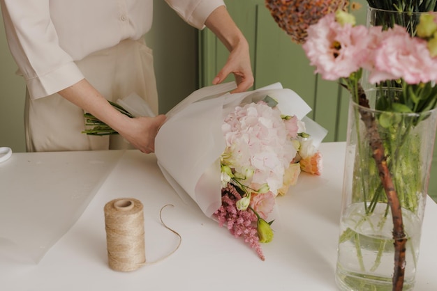 Schönes Mädchen sammelt einen Blumenstrauß in einem Blumenladen