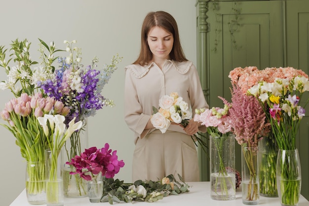 Schönes Mädchen sammelt einen Blumenstrauß in einem Blumenladen