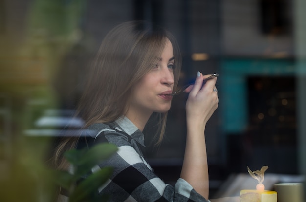 Schönes Mädchen trinkt Tee in einem Café