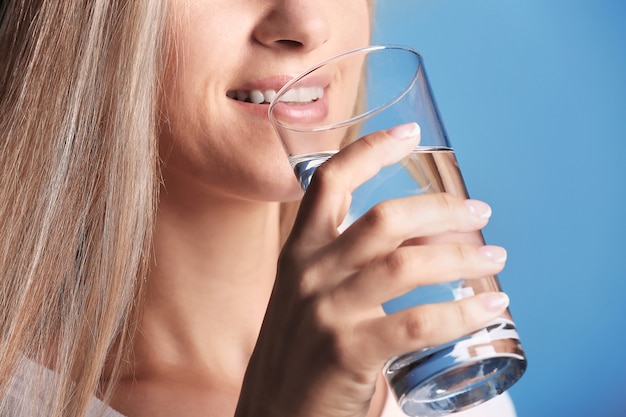 Schönes Mädchen Trinkwasser auf Blau