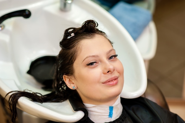 Schönes Mädchen waschen Haare im Salon