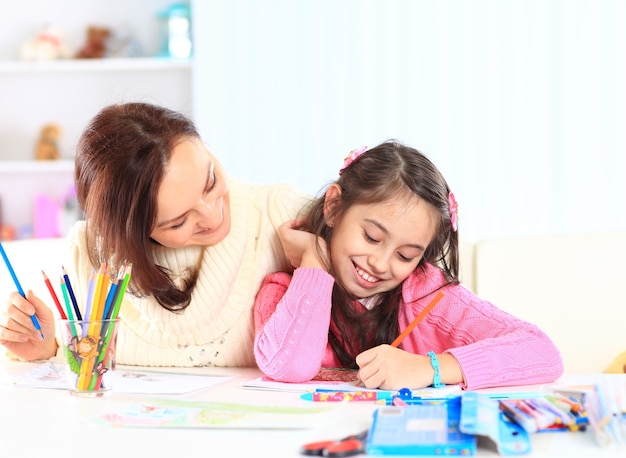 Schönes Mädchen zeichnet mit seiner Mutter