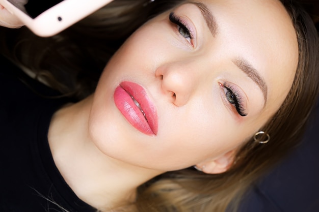 Schönes Mädchenmodell nach dem Verfahren des permanenten Lippen-Make-ups