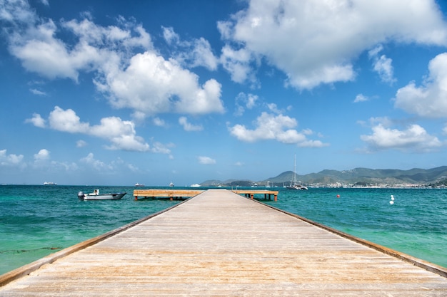 Schönes Marinedock mit Holzweghafen und Bootstransport auf dem Wasser sonnigen Sommer im Freien auf bewölktem Hintergrund des blauen Himmels